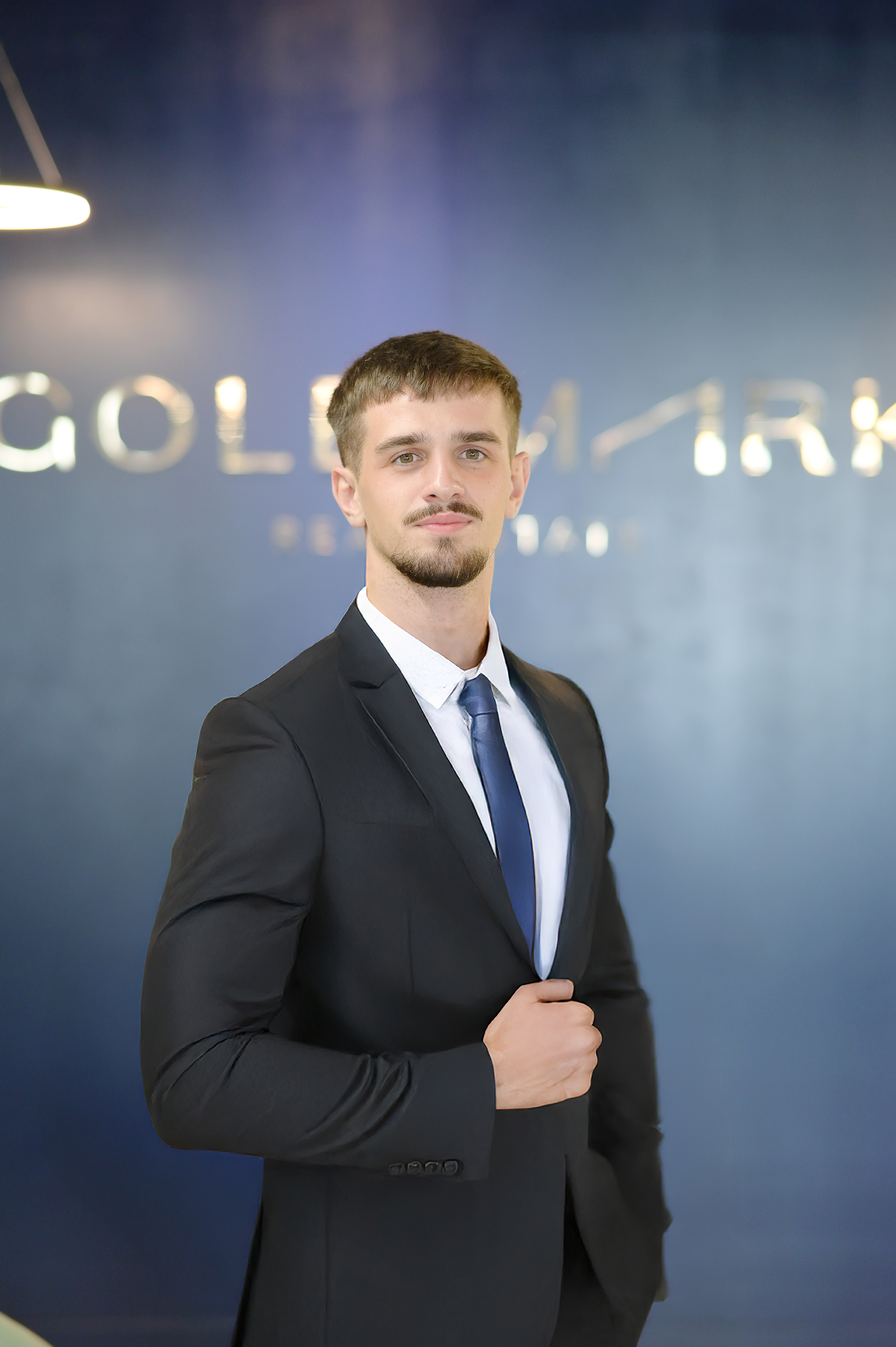 Joshua - Gold Mark Real Estate Agent. Joshua Kelly, sharp in his best attire, at the Gold Mark Real Estate office. A long way from Dublin, but clearly at home in his new world.